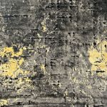 Textured abstract rug with gold, charcoal, and yellow pattern, featuring a black lower pile.