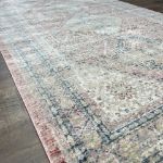 Muted pinkish-red diamond trellis rug featuring cream, beige, and soft gray accents with durable cotton backing