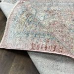 Sophisticated vintage-style area rug with muted pinkish-red diamond trellis pattern and soft short pile for home decor