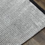 Elegant Mystique polyester rug featuring silver gray stripes and decorative black tassels.