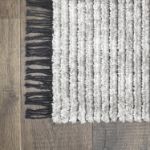 Modern silver gray striped area rug with plush pile and chic tassel accents.