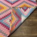 Turkish kilim carpet with boho tribal designs in pink, yellow, turquoise, and maroon